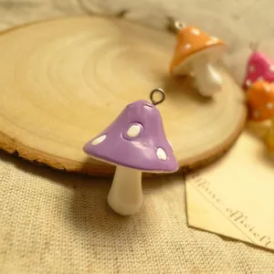 Macro shot of purple resin mushroom charm with white dots and metal ring hook