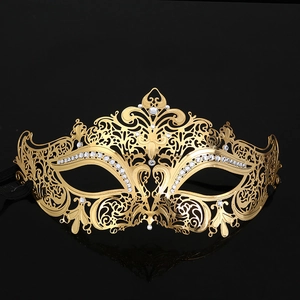 Detailed close-up of gold metal laser-cut mask with sparkling white rhinestones