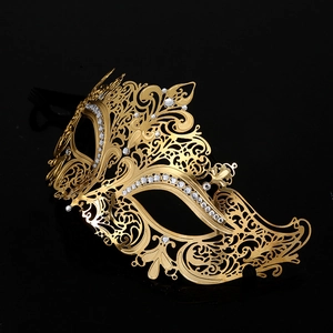 Golden laser-cut metal masquerade mask with sparkling rhinestones on a black background