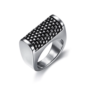 Macro shot of polished silver steel skull ring featuring black bead texture and brushed finish