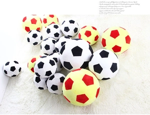 Detail of plush soccer ball toys in classic black-white and red-yellow soft plush fabric