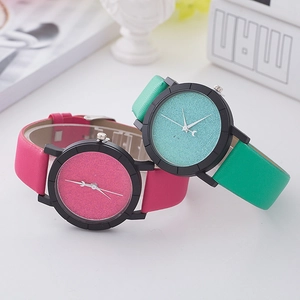 Minimalist quartz watches with glitter dials and moon decorative hands on a clean desk