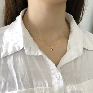 Close-up of a 925 sterling silver necklace with a marquise pink zircon pendant on a woman