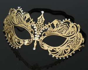 Close-up of golden laser-cut metal masquerade mask with sparkling white rhinestones
