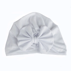 Detailed view of baby white cotton turban hat featuring a large soft decorative bow