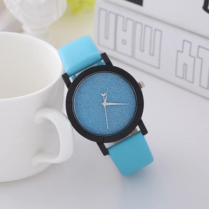Quartz watch with blue starry sky dial and light blue leather strap leaning on a cup