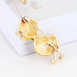 Back view of yellow duckling enamel brooch showing the gold-plated pin and base texture