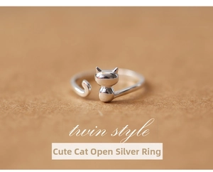 Macro shot of silver adjustable open ring featuring cute cat head and tail details