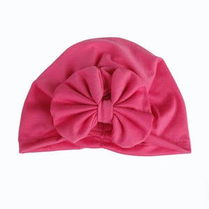 Detail of hot pink cotton baby turban hat featuring a large soft bow decoration