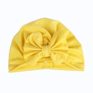 Detail of yellow cotton baby turban hat with a large decorative bow and ribbed knit texture