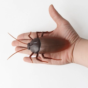 Realistic large infrared remote control cockroach toy held in hand for scale