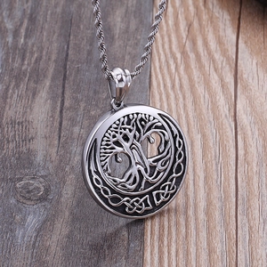 Silver Tree of Life pendant necklace with woven hollow design on vintage wood background