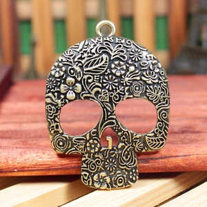 Carved rose skull pendant in vintage bronze finish with floral vine relief pattern