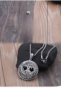 Detailed close-up of vintage Tree of Life pendant with Celtic knot edge on dark pebble