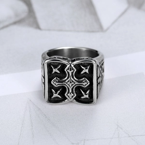 Macro shot of retro stainless steel cross ring featuring vintage oxidized star patterns