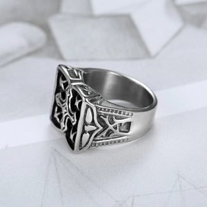 Macro shot of vintage stainless steel ring with gothic cross relief and oxidized finish