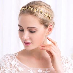 Detailansicht eines goldenen Braut-Stirnbands mit funkelnden Strasssteinen in Blattform