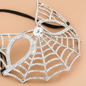 Macro shot of sparkling rhinestones on silver-tone spider web bridal mask detail