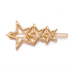 Detail of golden metal hair clip featuring three connected hollow star shapes on white backdrop