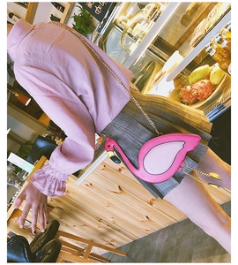 Close-up of pink flamingo crossbody bag featuring gold chain strap and tassel details