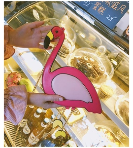 Detailed view of pink flamingo crossbody bag with golden chain strap and feather charm