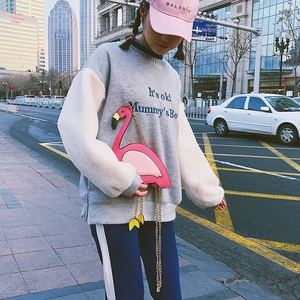 Detailed shot of pink flamingo crossbody bag with gold chain strap on female model