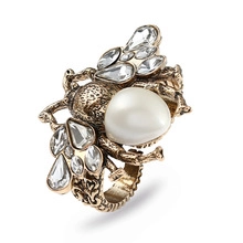 Macro view of vintage gold bee ring featuring white pearl and crystal flower petals