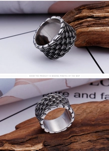 Macro detail of vintage titanium steel ring featuring woven texture and a dark grey gemstone
