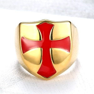 Detail of shield-shaped ring with red cross emblem and polished gold plating
