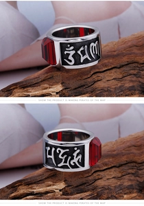 Detail shot of vintage titanium steel ring with red gemstone and engraved Buddhist mantras