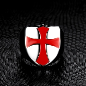 Macro detail of silver crusader shield ring with red enamel cross on black leather