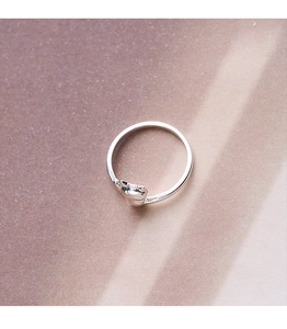 Close-up of polished silver cat head detail on a minimalist adjustable open ring