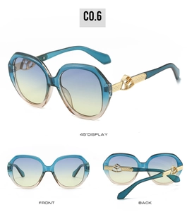 Detail view of oval sunglasses with blue gradient lenses and golden filigree temples