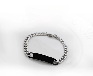 Detailed close-up of a silver Cuban link chain bracelet with a black metal rectangular plate
