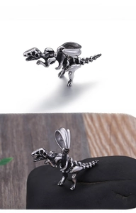 Macro shot of retro silver stainless steel Tyrannosaurus skeleton pendant on stone base