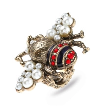 Detailed close-up of retro bee ring with white faux pearls and red rhinestones