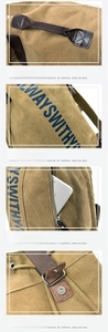 Detail view of khaki canvas backpack showing leather handle and magnetic snap button closure