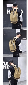 Small khaki canvas drawstring backpack featuring leather straps and decorative text details