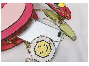 Pink oval flamingo crossbody bag with gold chain strap and yellow smiley face coin purse