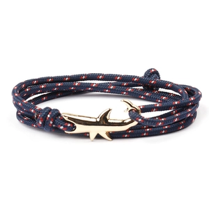 Detail of nautical braided rope bracelet with red white blue cords and golden shark clasp