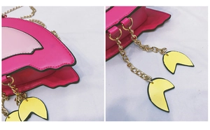 Detailed view of pink flamingo crossbody bag with golden chain and yellow leaf charm