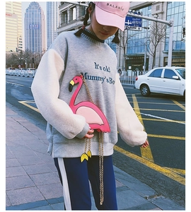 Detail shot of a pink flamingo-shaped crossbody chain bag paired with a gray sweatshirt