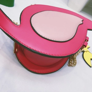 Detail of pink flamingo shaped crossbody bag featuring a shiny gold metal chain strap