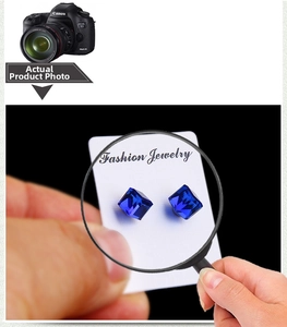 Macro shot of dark blue square-cut crystal magnetic studs shown through a magnifying glass