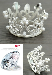 Detail of silver bridal crown featuring delicate rhinestones and white pearls on a circular frame