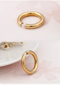 Detailed view of a gold-plated titanium ring with a round zircon in tension setting