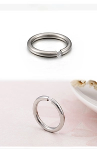 Macro detail of silver titanium steel ring featuring a tension-set round cubic zirconia