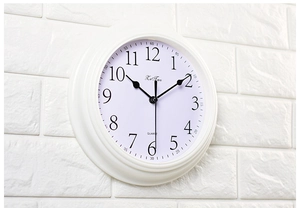 Detail view of white silent wall clock with black 3D numerals and quartz movement