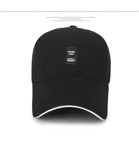 Detail of black cotton baseball cap showing woven label text and white edge trim