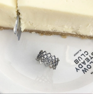 Close-up of a 925 sterling silver woven ring with vintage twisted rope pattern on a plate